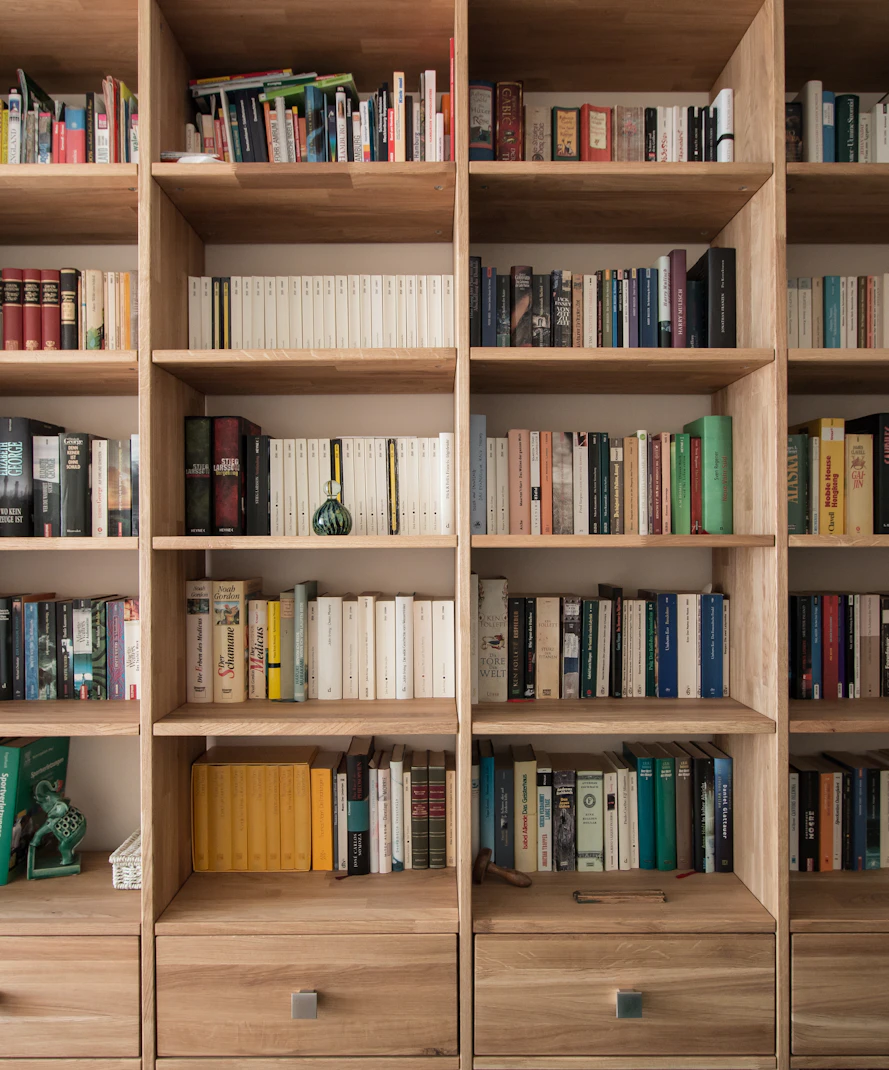 Oak shelves lined with books, floor to ceiling