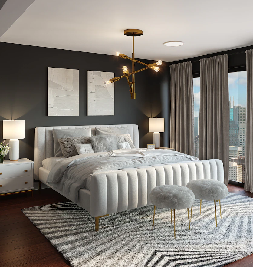 A primary bedroom with a deep charcoal feature wall behind a channel-tufted bed.
