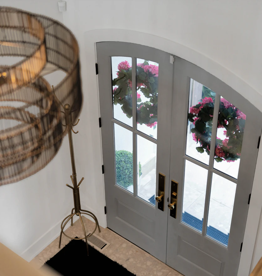 An entry hall with arched double front doors, freshly painted.