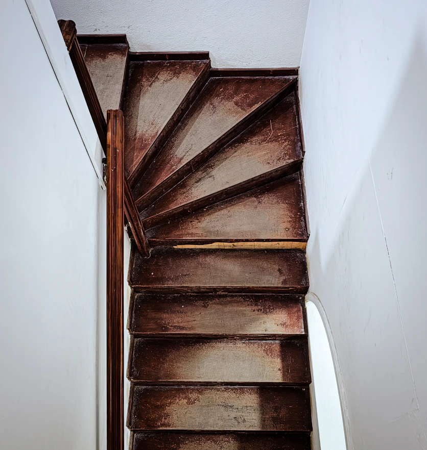 A bare wooden staircase stripped back and sanded, ready for primer.