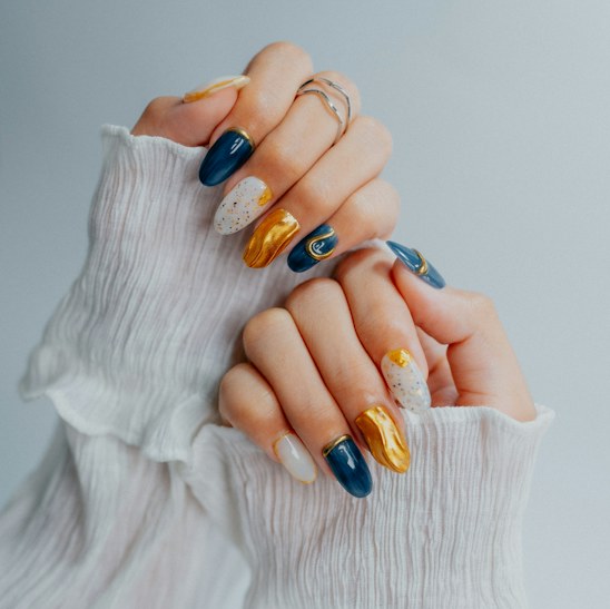Almond nails in navy, gold and white with abstract artwork