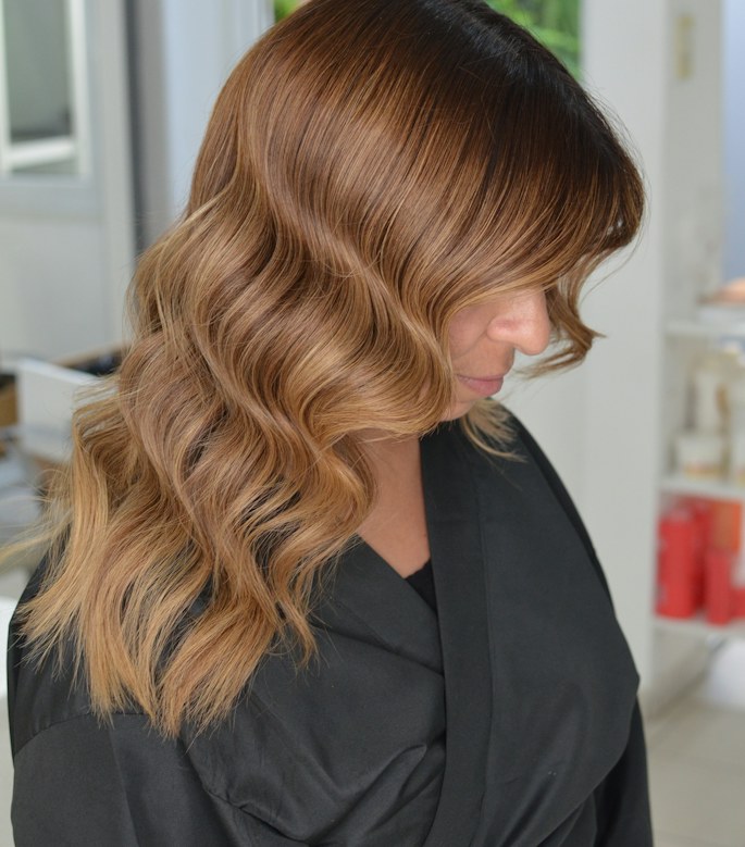 Blonde balayage with soft waves, shot from behind