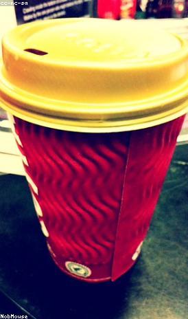 A red takeaway cup with a lid, on the counter