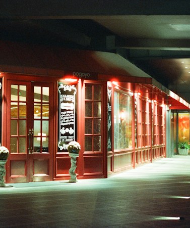 The doorway of Umeko Sushi lit up at night, with the sign above.