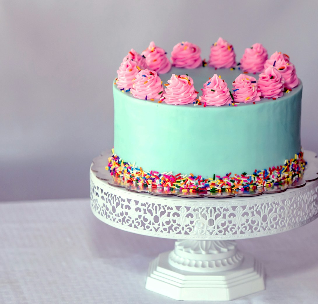 A piped cake on a white stand