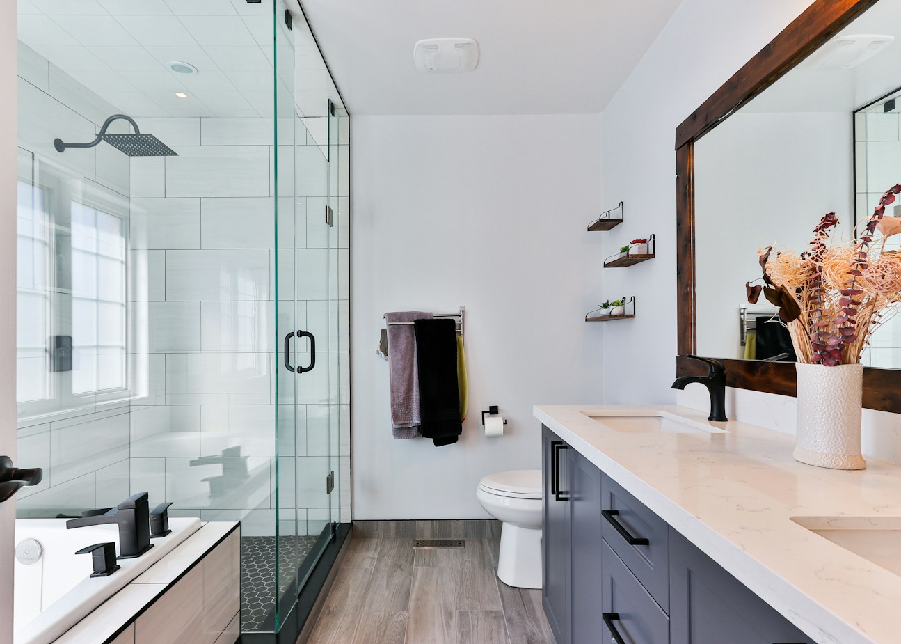 Renovated bathroom with frameless glass shower, floating vanity and wood-look tile floor