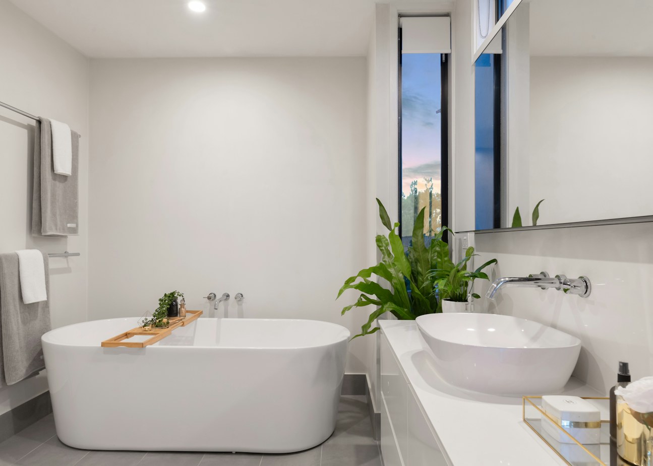 Bathroom with freestanding tub, vessel basin and wall-mounted faucet